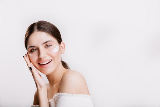 A beautiful woman is applying skin care products